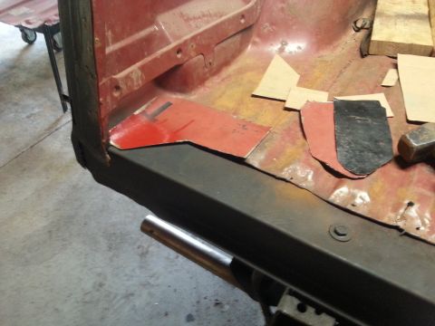 1984 Ford Bronco - Photograph of a pickup bed corner with sheet-metal and cardboard patch templates during repair.
