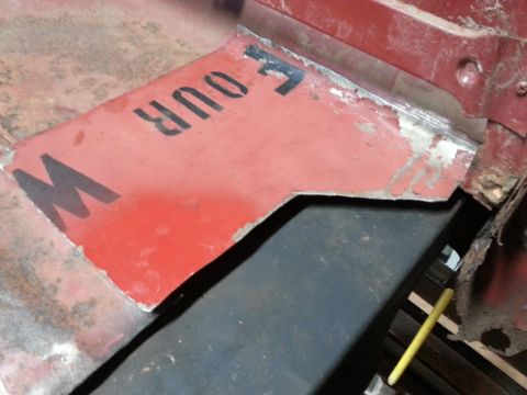 1984 Ford Bronco - Photograph of a patch panel cut from a repurposed painted metal sign placed on a truck bed.