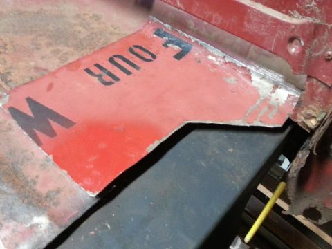 1984 Ford Bronco - Photograph of a patch panel cut from a repurposed painted metal sign placed on a truck bed.
