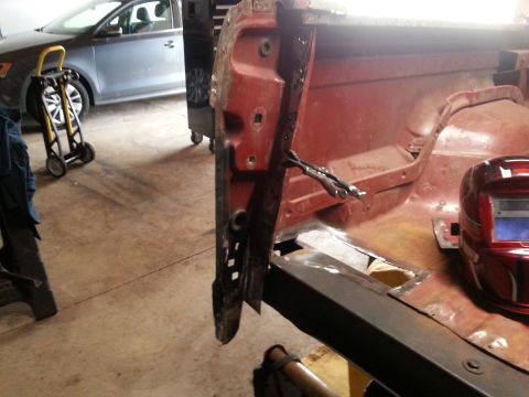 1984 Ford Bronco - Workshop photo of a red vehicle body shell during sheet-metal restoration, not a technical document.