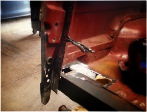 1984 Ford Bronco - Workshop close-up of a welded body-mount area on a red vehicle shell, not a technical document.