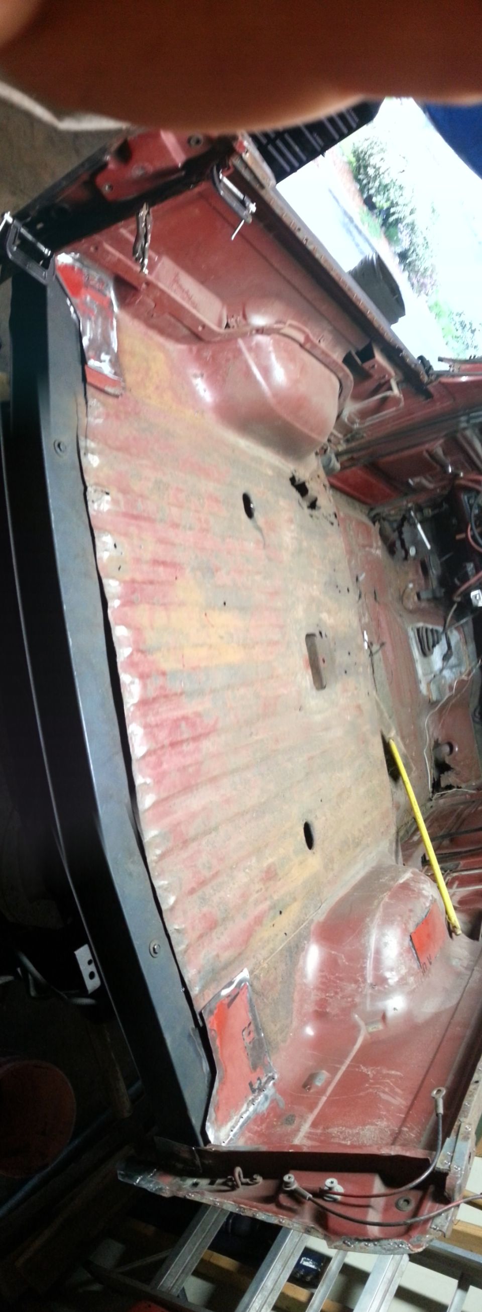 Photo of a red bare cab floor pan during vehicle restoration