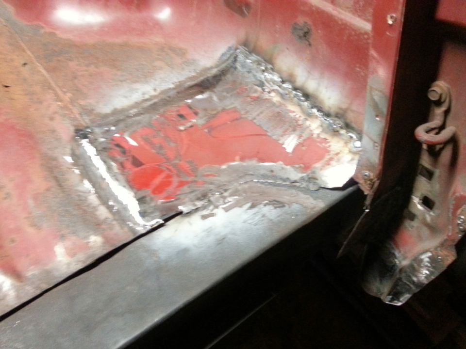 Close-up photo of a welded floor patch panel near a body mount