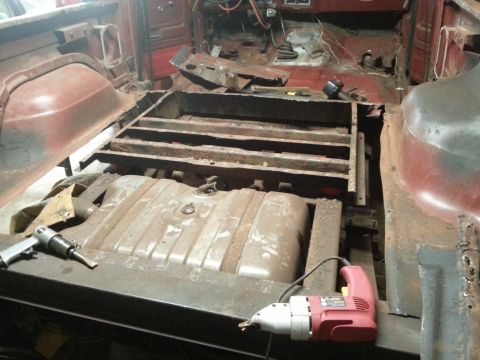 1984 Ford Bronco - Photo of a truck with floor removed exposing the frame rails and fuel tank during restoration.