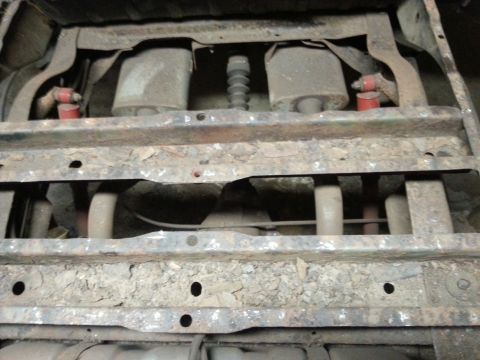 1984 Ford Bronco - Photo of a vehicle's underbody showing frame crossmembers and corroded floor structure.