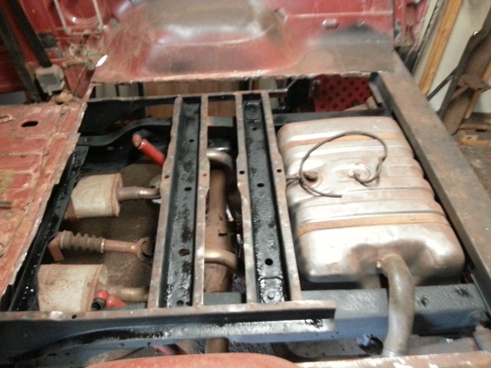 Vehicle underbody showing frame rails, driveshaft, sway bar and fuel tank
