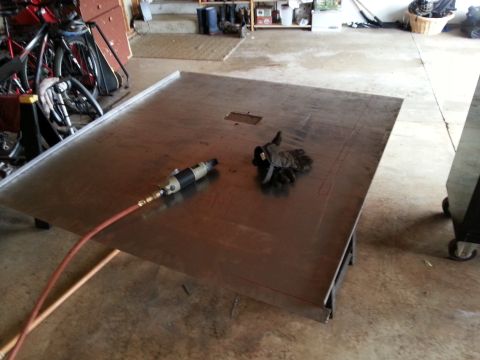 1984 Ford Bronco - Photo of a fabricated metal floor panel and air tool on stands during restoration.