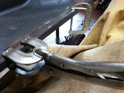 1984 Ford Bronco - Photo of locking pliers and a clamp securing metal on a fabrication table during restoration.