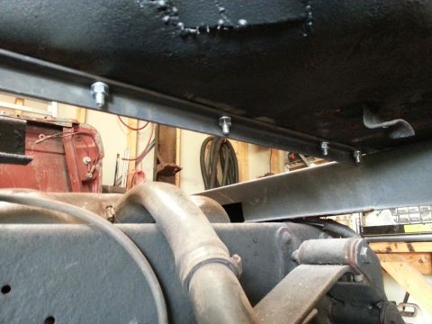 1984 Ford Bronco - Undercarriage restoration photo of bolted brackets and an exhaust pipe, not a technical document.