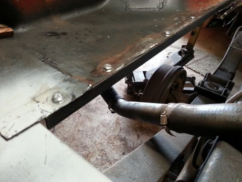 1984 Ford Bronco - Undercarriage restoration photo near a brake drum and exhaust pipe, not a technical document.