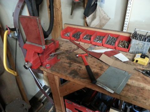 1984 Ford Bronco - Workshop photo of a bench vise, hammer and fastener bins on a workbench, not a technical document.