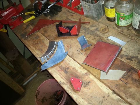 1984 Ford Bronco - Workshop photo of cut metal patch pieces and welding magnets on a bench, not a technical document.