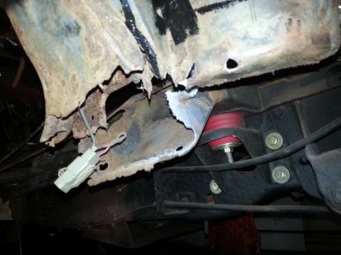 1984 Ford Bronco - Undercarriage photo of rusted body metal above a polyurethane bump stop, not a technical document.
