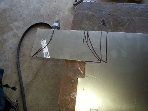 1984 Ford Bronco - Workshop photo of sheet-metal stock marked for cutting on the floor, not a technical document.