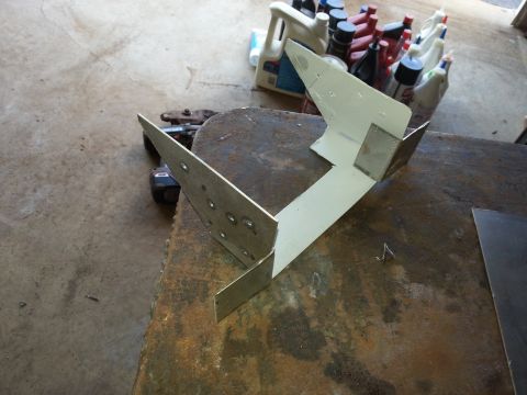 1984 Ford Bronco - Workshop photo of a fabricated multi-bend metal bracket, not a technical document.