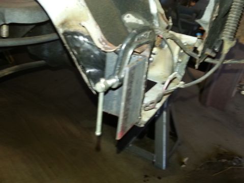 1984 Ford Bronco - Photo of a welded inner body bracket and bare-metal repair panel on a vehicle frame supported on a stand.