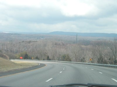 1997 Ford Taurus - A highway curves through a bare, wooded landscape under an overcast sky. Text from Supermotors.net is visible at the bottom right.
