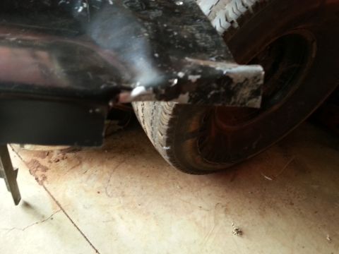 1984 Ford Bronco - Photo of the lower rear body and wheel of a vehicle showing welding work on a shop floor.