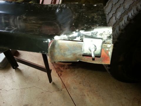 1984 Ford Bronco - Photo of a lower body panel end with a bare-metal repair, the rear tire visible behind it.