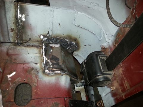 1984 Ford Bronco - Photo of a welded inner-body repair near the door hinge area showing burnt and bare metal.