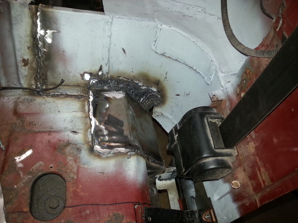 Welded inner body repair near a door hinge area with burnt and bare metal
