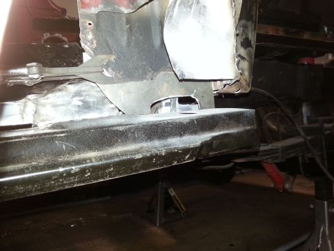 1984 Ford Bronco - Photo of an underbody rocker and frame area with a bare-metal weld repair, vehicle on jack stands.