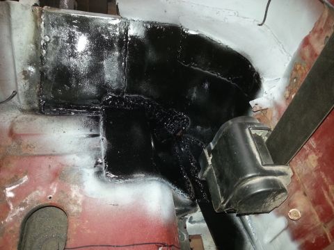 1984 Ford Bronco - Photo of a seam-sealed, black-coated inner body repair around a seatbelt mount during restoration.