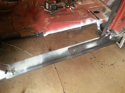 1984 Ford Bronco - Photo of a new bare-metal rocker panel fitted along the lower body of a vehicle in a shop.
