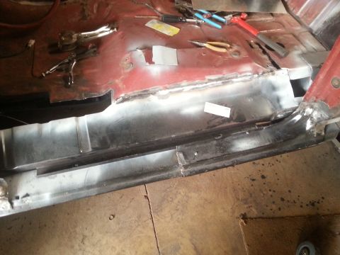 1984 Ford Bronco - Photo of a bare-metal rocker panel welded along a vehicle floor with hand tools scattered nearby.