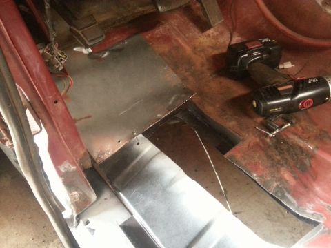 1984 Ford Bronco - Photo of a vehicle floor with new metal patch panels installed and a cordless drill, during restoration.