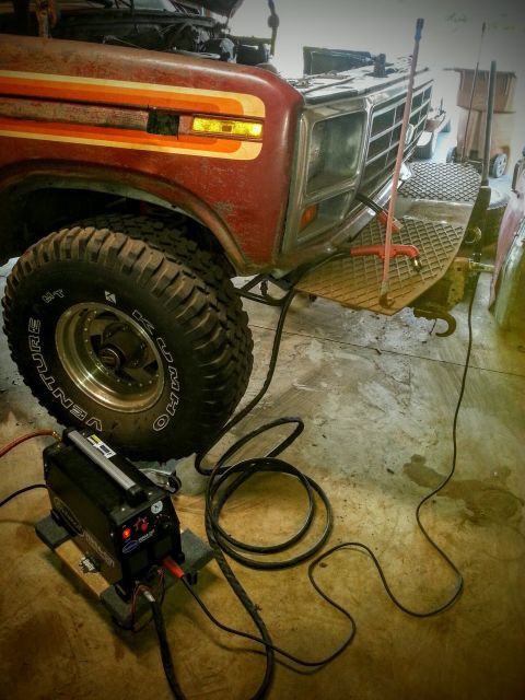 1984 Ford Bronco - Photo of a vintage Ford truck front end in a workshop with a welding machine, not a technical document.