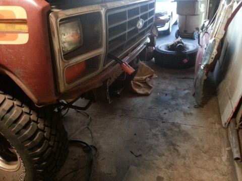 1984 Ford Bronco - Photo of a vintage Ford truck front end and spare differential in a garage, not a technical document.
