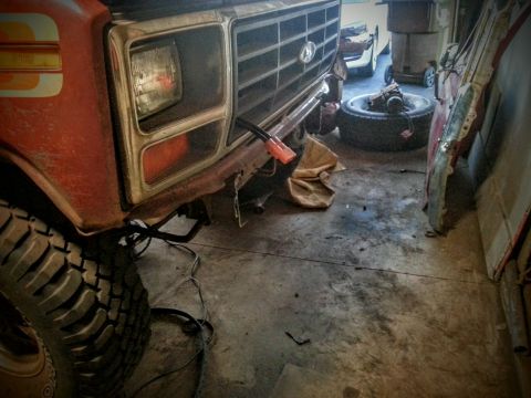 1984 Ford Bronco - Photo of a vintage Ford truck front grille and headlight area in a garage, not a technical document.
