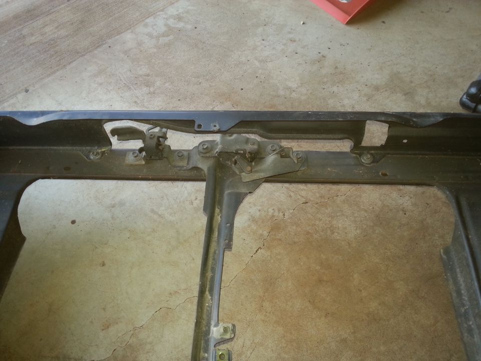 Close view of a removed radiator support center brace with hood latch