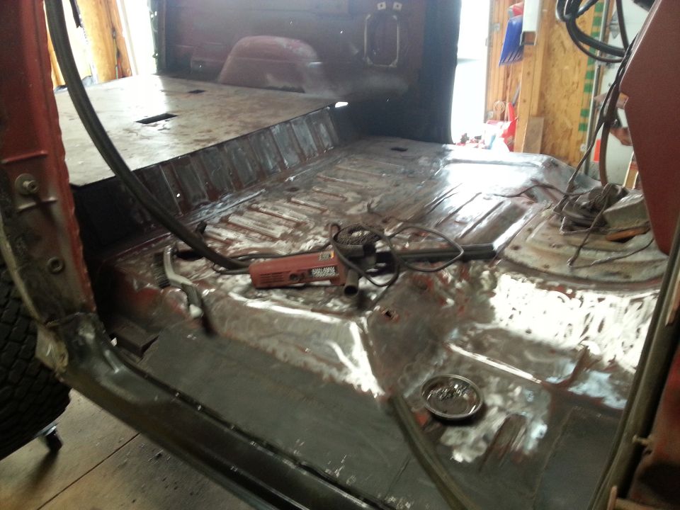Bare metal truck bed floor with welded seams during restoration
