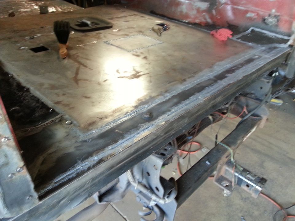 Bare metal truck floor pan welded to frame, viewed from below