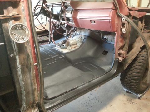 Truck cab interior with primed floor pan, exposed dash, and door opening
