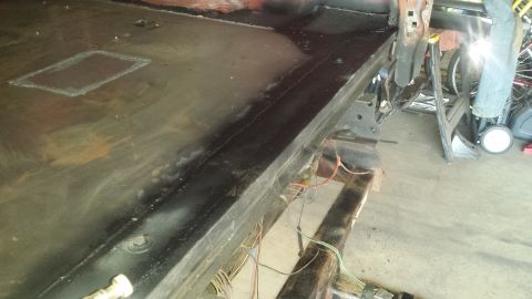 Painted black truck bed floor and rear frame with wiring during restoration