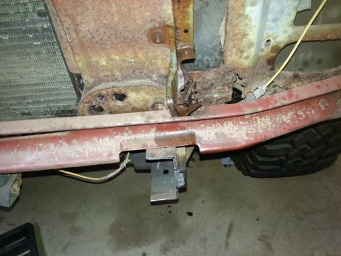 Red front bumper support and radiator core support of a classic truck on a garage floor