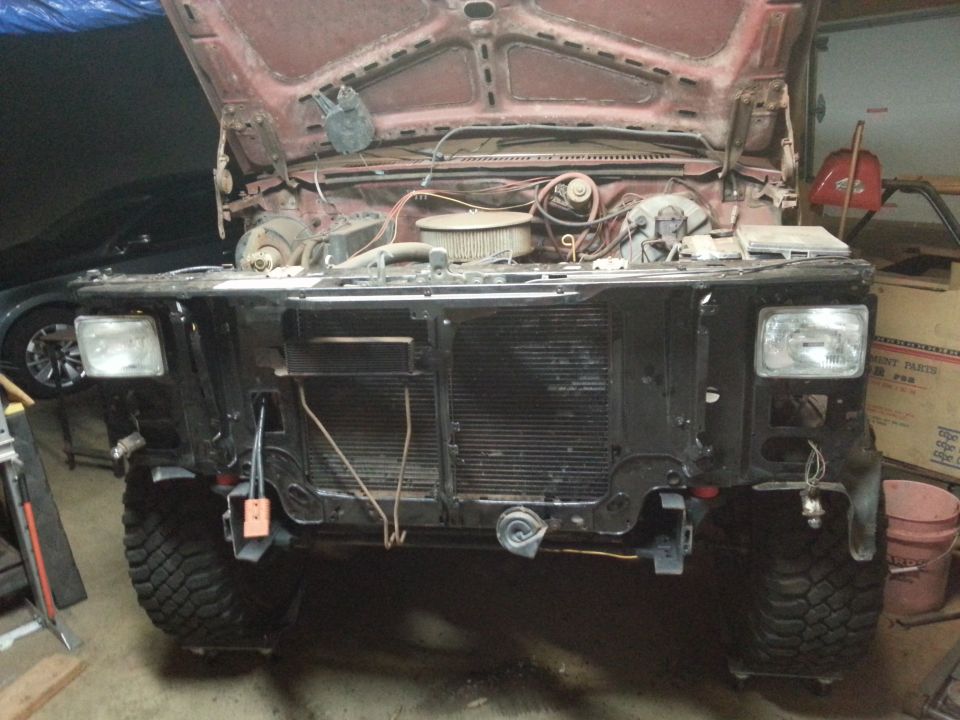Front end of a classic truck with headlights installed and radiator exposed, hood up
