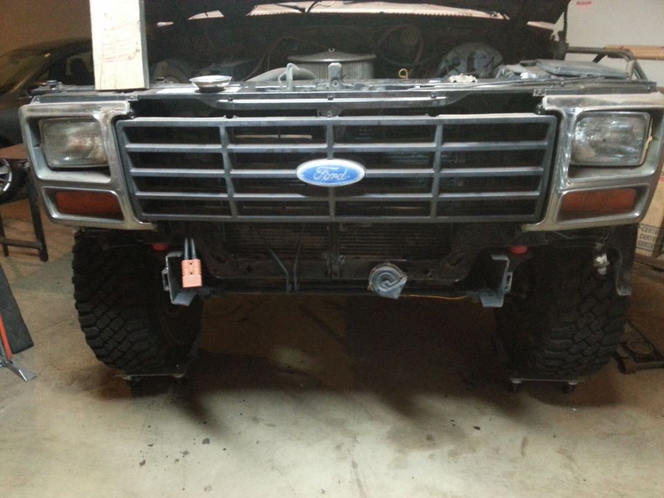Front of a Ford truck with chrome grille, blue oval emblem and amber marker lights