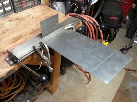 Sheet metal clamped in a bending brake on a workbench