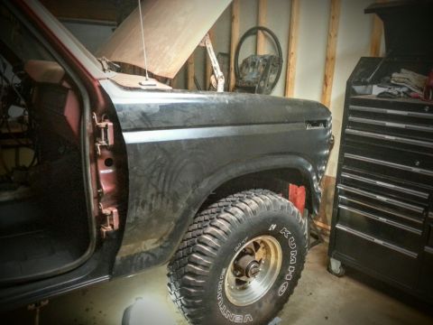 Truck with hood open and fender removed in a garage