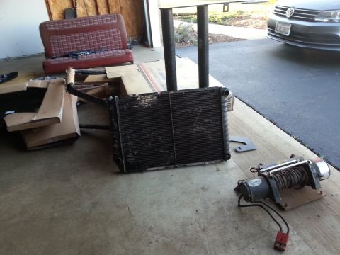Radiator and winch on a garage floor near a seat