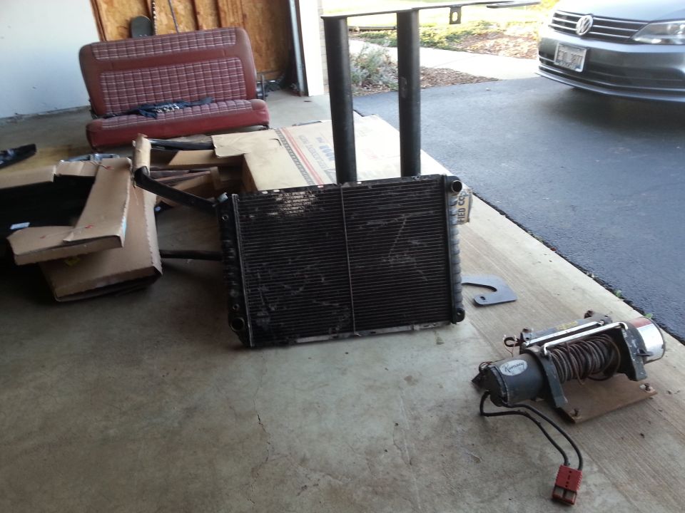 Radiator and winch on a garage floor near a seat