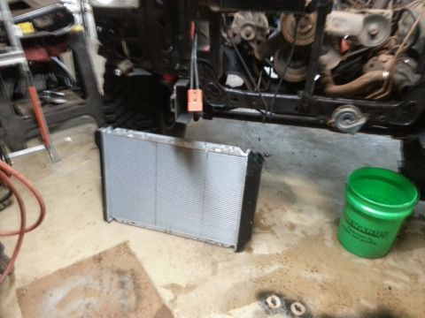 New aluminum radiator leaning beside a vehicle frame