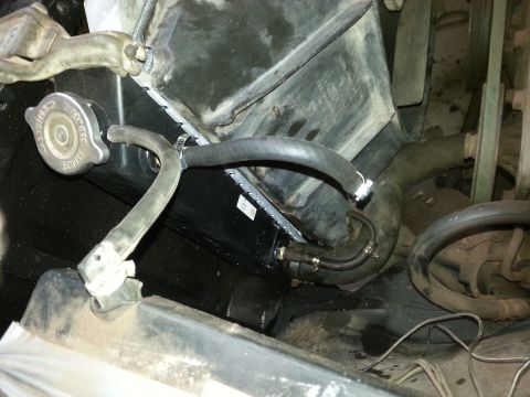 Radiator, cap and hoses viewed in an engine bay