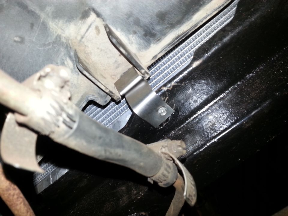 Bracket and hose at a radiator and frame mount point