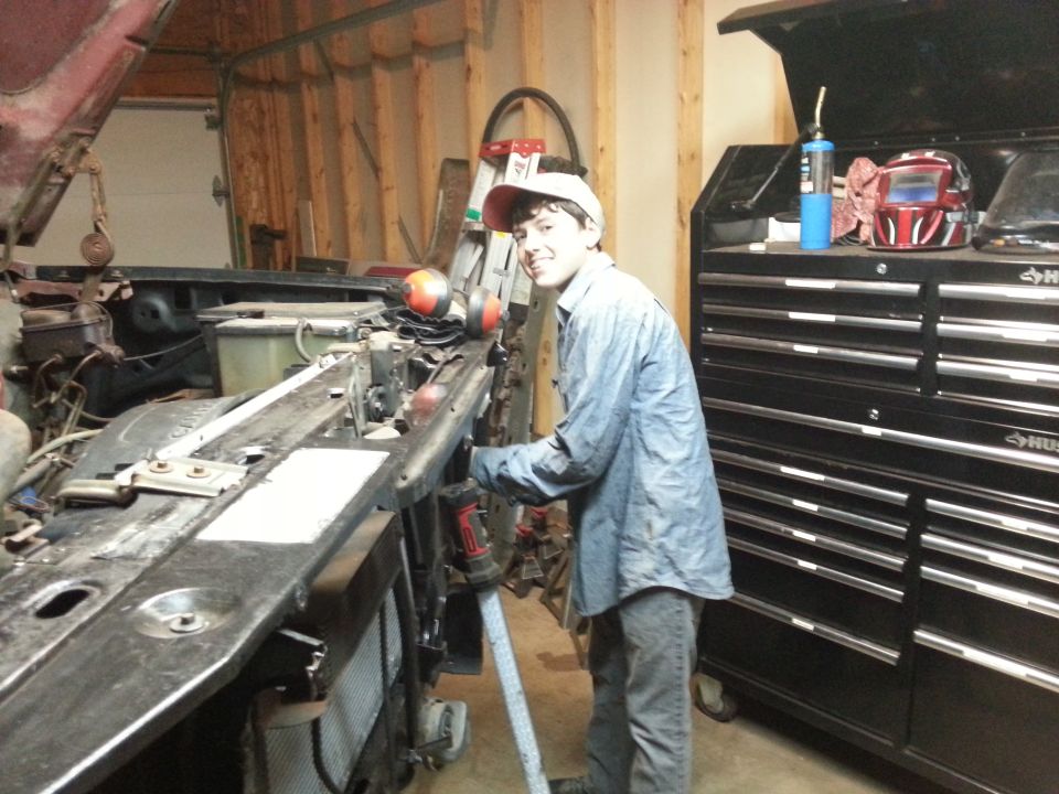 Person working on a truck front end in a garage