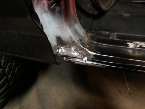 Close-up photo of welded and ground metal repair on a vehicle rocker panel